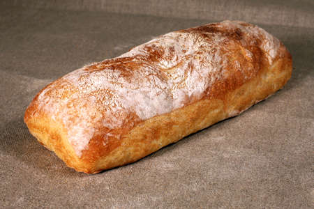 white bread lies on a grey linen tableclothの写真素材