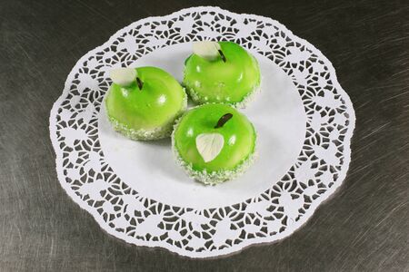 three servings of sweet cake in the shape of apples on a white cloth on a gray backgroundの写真素材