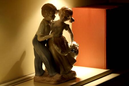 porcelain figurine boy and girl on the shelf with the booksの写真素材