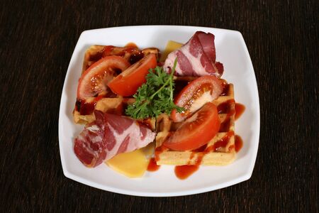 appetizer of bacon and baking in a sauce with tomatoes and cheeseの写真素材