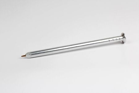 metal pen in the shape of the nail on white backgroundの写真素材