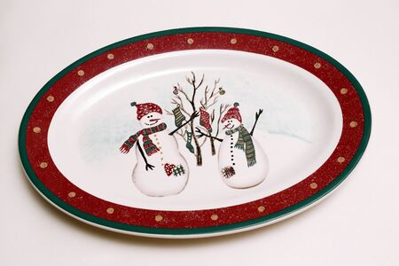 porcelain dining plate with image of two snowmen in hats and scarvesの写真素材