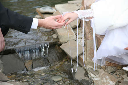 groom holds the bride by the hand closeup