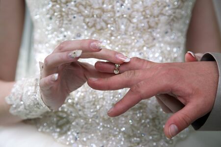 bride and groom wear wedding rings to each otherの写真素材