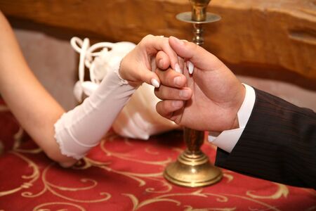groom holds the bride by the hand closeupの写真素材