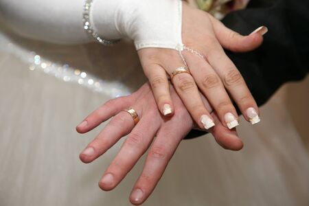 bride and groom show their hands wearing wedding ringsの写真素材