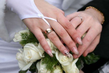 hands of bride and groom near wedding bouquetの写真素材