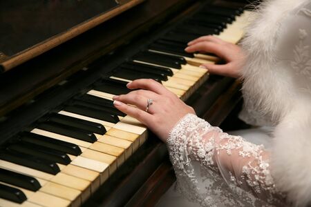 bride plays the piano closeupの写真素材
