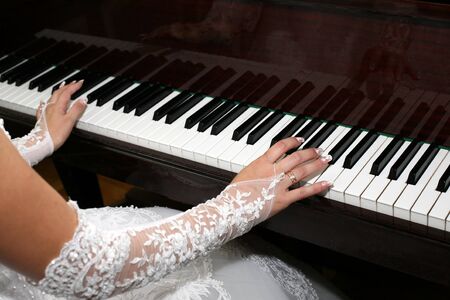bride plays the piano closeupの写真素材