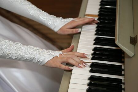 bride plays the piano closeupの写真素材