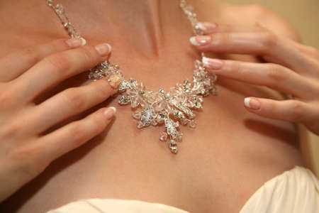 the bride straightens his jewelry on the neckの写真素材