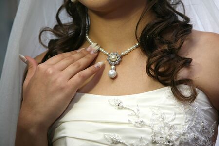 the bride straightens his jewelry on the neckの写真素材