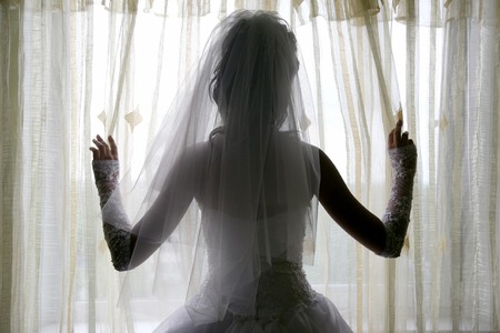 the silhouette of the bride standing near the windowの写真素材