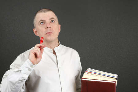 white man with pen and books in hand looking to the topの写真素材