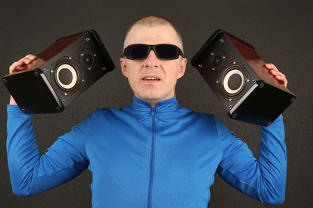 man in dark glasses holding two powerful speakersの写真素材