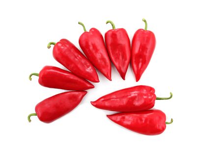 eight bright red sweet peppers on a white backgroundの写真素材