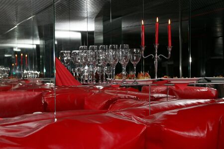 glasses and candles in red interior with mirrorsの写真素材