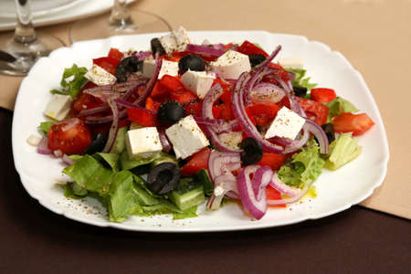 salad vegetables and cheese in a white plateの写真素材