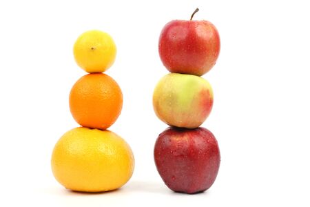 apples and citrus stand vertically on each other on white backgroundの写真素材