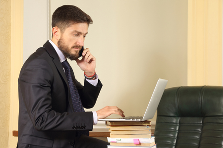 successful business man in office working with laptopの写真素材