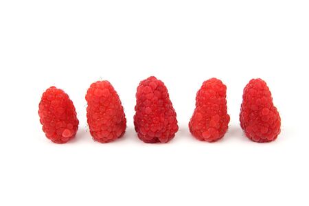 raspberries in a row lying on white background