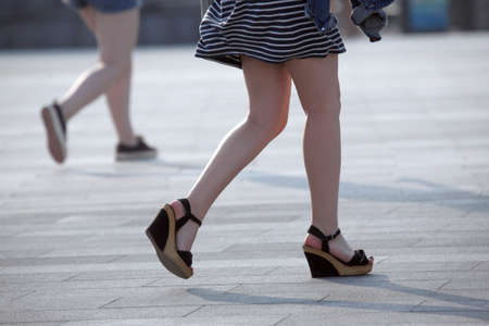 walking women legs in backlight sunlight