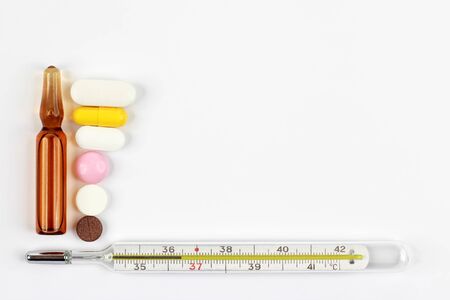 medicinal tablets, thermometer and ampoule on a white background
