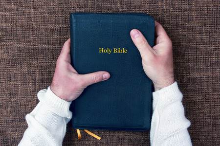the holy bible in the hands of manの写真素材