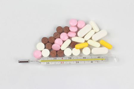 medicinal tablets, thermometer on a white background