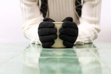 men hands in black gloves with a cup of teaの写真素材