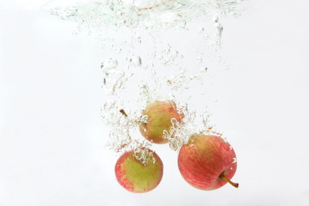 apples fall into the waterの写真素材