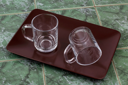 two transparent cups on a brown plateの写真素材