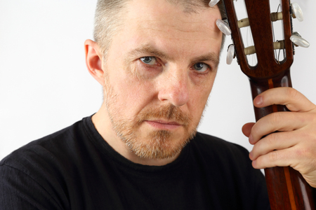 portrait of a male musician with a acoustic guitar