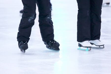 the legs of a man skating on an ice rinkの写真素材
