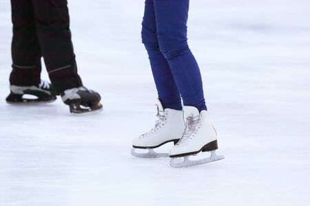 the legs of a man skating on an ice rinkの写真素材
