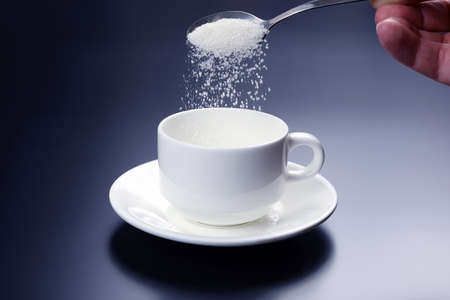 white cup with spoon with sugar