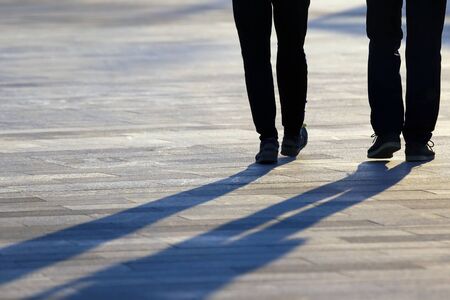 legs of two people coming together in the squareの写真素材