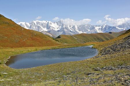 mountain lake in the snowy backdrop of the Caucasus mountain range in Georgiaの写真素材