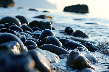 wet pebbles on the sea shore closeupの写真素材