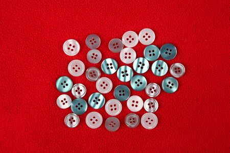 different mother of pearl buttons on a red cloth