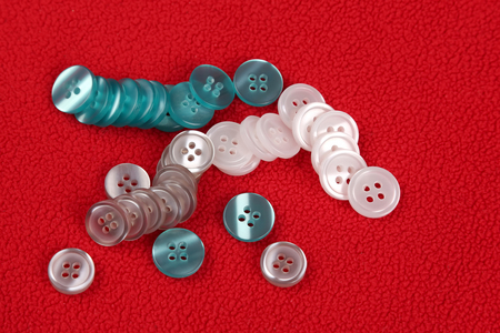 different mother of pearl buttons on red fabric