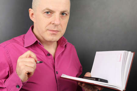 portrait of business man in a shirt with a pen and documentsの写真素材