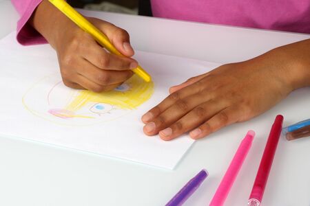 hands black girls draw a yellow pencil face