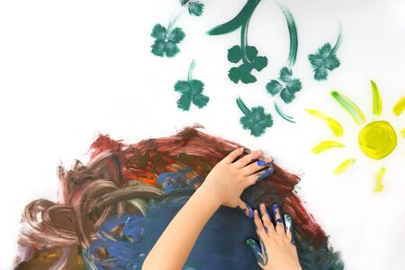 Children hand paint a picture with paints on white backgroundの写真素材