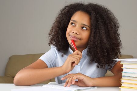 black schoolgirl is thinking about school homework doing homework