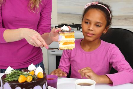 mom buys daughter a piece of cakeの写真素材