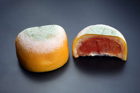 cut the rotting grapefruit on a dark backgroundの写真素材