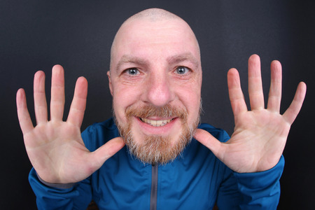 cheerful bearded man with his hands upの写真素材