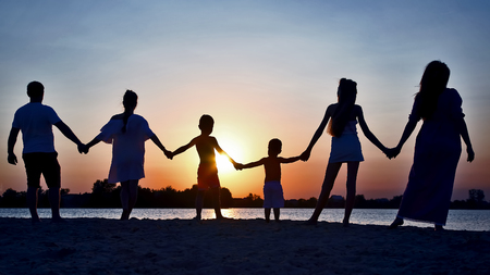 Silhouette of family on sunset backgroundの写真素材