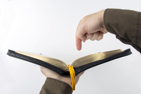 The index finger points to the text in the open Bible
